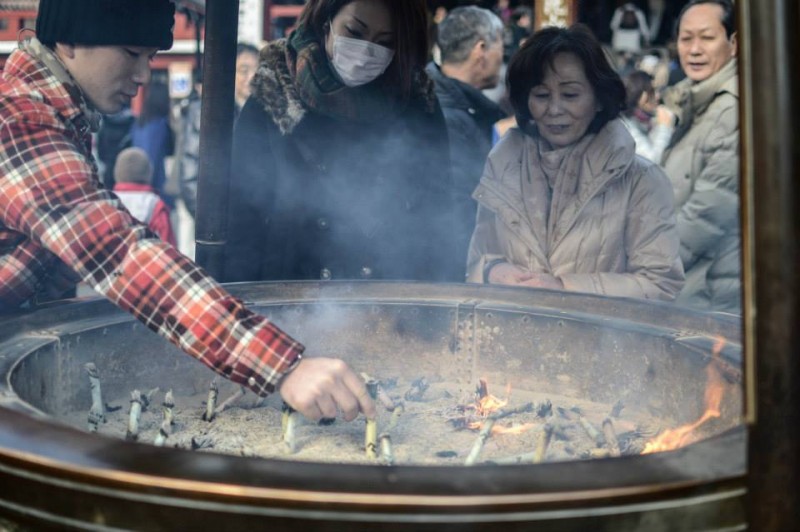 Újévi templomlátogatók gyújtanak füstölőket Sensoujinél.